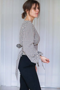 Seitenansicht der Paloma Wickelbluse aus braun kariertem Seersucker mit Vichy-Karo, gebundener Taille und gerafften Ärmeln