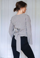 Rückenansicht der Paloma Wickelbluse mit gebundener Taille und leicht ausgestellten Ärmeln.