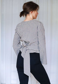 Rückenansicht der Paloma Wickelbluse mit gebundener Taille und leicht ausgestellten Ärmeln.