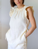 Detailansicht von Leinenkleid Muriel mit breiten Ärmelvolants und gerafftem Halsausschnitt sowie seitlichen Eingriffstaschen, aus buttergelbem Leinen
